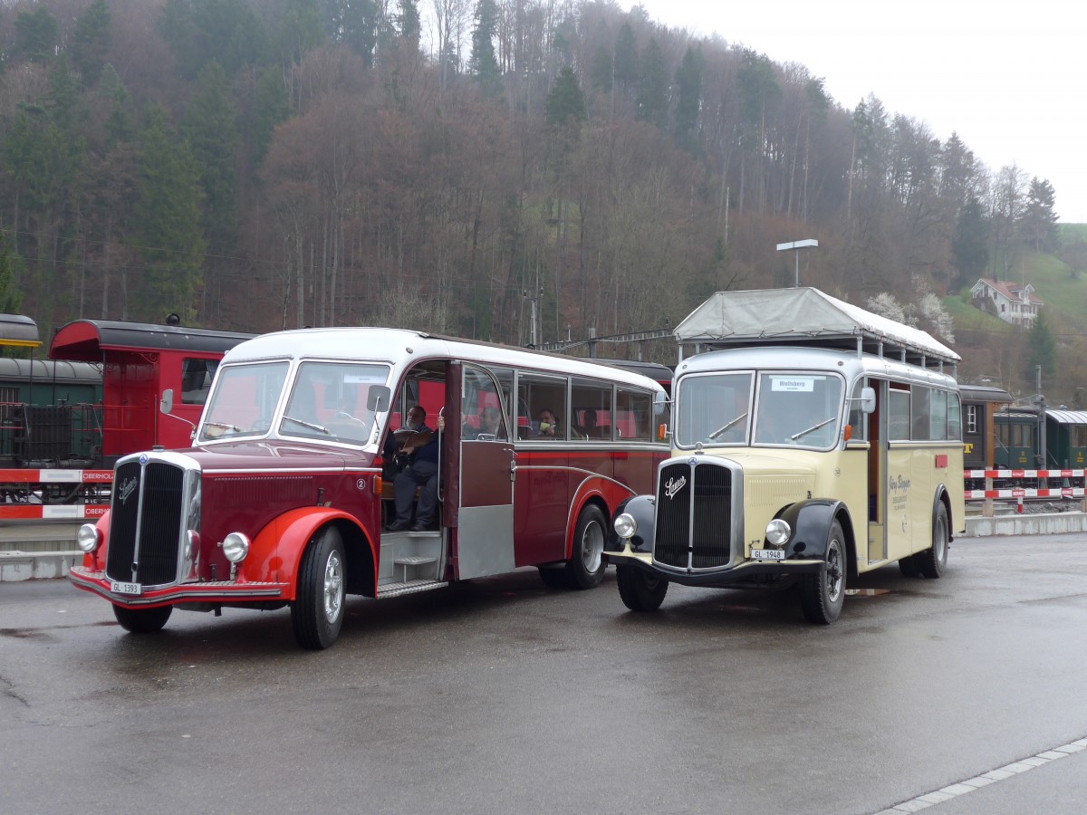 (149'585) - Biegger, Uster - Nr. 2/GL 1393 - Saurer/Lauber (ex T�l�verbier, Verbier Nr. 2; ex Werkbus; ex Rey, Ayent) + Nr. 32/GL 1948 - Saurer/R&J (ex Redbull (Schweiz), Baar; ex Brandt, D-Reichersbeuern; ex Bach, NL-Amsterdam; ex H�gli, Steinach; ex EHC Biel; ex Leuenberger, Thun; ex AvH Heimenschwand) am 6. April 2014 beim Bahnhof Bauma